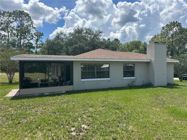 2510 W Dolphin Dr, Citrus Springs, FL 34434 - back of property with a sunroom, a yard, a chimney, and stucco siding