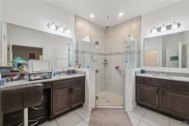 bathroom with tile patterned flooring, vanity, and a shower with door