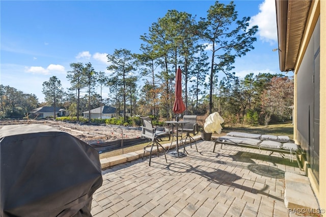 wooden deck with area for grilling and a patio area