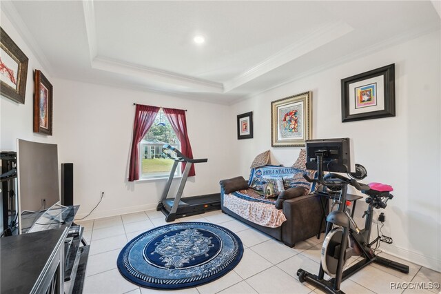 exercise room with light tile patterned floors, ornamental molding, and a tray ceiling