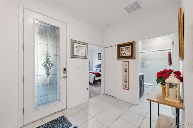 foyer featuring light tile patterned floors and ornamental molding