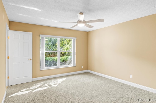 carpeted spare room with ceiling fan and a textured ceiling