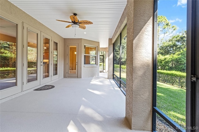 unfurnished sunroom with ceiling fan