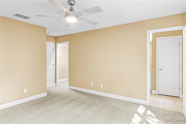 unfurnished room with light colored carpet and ceiling fan