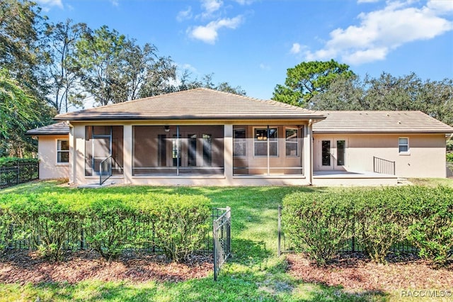 back of house featuring a yard and a sunroom