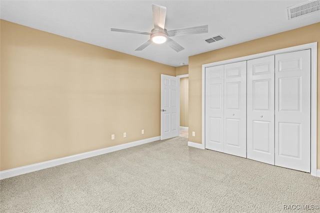 unfurnished bedroom featuring ceiling fan, light carpet, and a closet