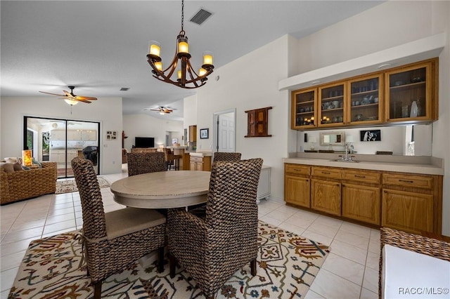 dining space with light tile patterned flooring, visible vents, and ceiling fan with notable chandelier