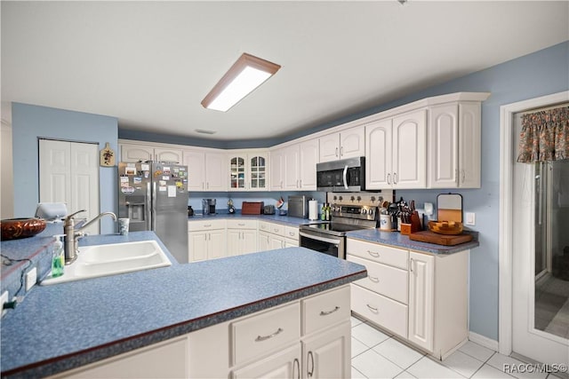 11271 SE 136th Ter, Dunnellon, FL 34431 - kitchen with stainless steel appliances, glass insert cabinets, light tile patterned floors, white cabinets, and dark countertops