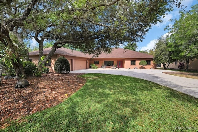 ranch-style home with a garage, a front lawn, stucco siding, and concrete driveway