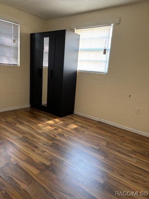 interior space with dark hardwood / wood-style flooring and ornamental molding