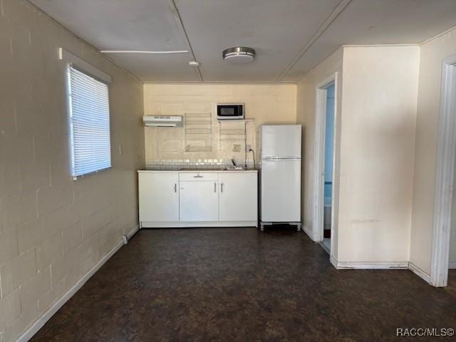 kitchen with white cabinetry and white fridge