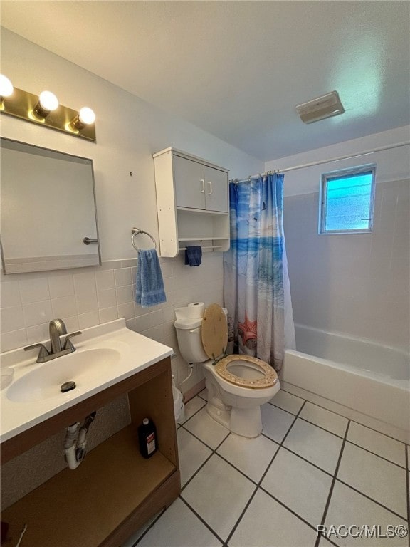 full bathroom featuring tile patterned floors, sink, tile walls, shower / bathtub combination with curtain, and toilet