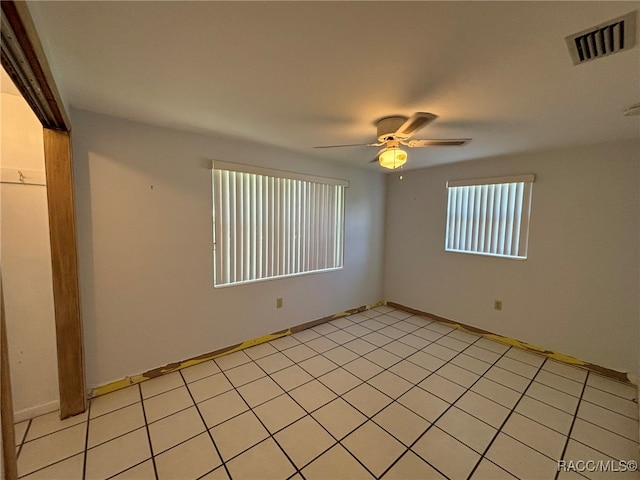 tiled spare room featuring ceiling fan