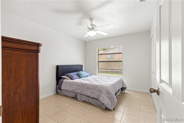 bedroom with light tile patterned floors, a textured ceiling, and ceiling fan