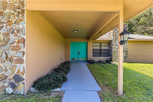 view of exterior entry with a lawn