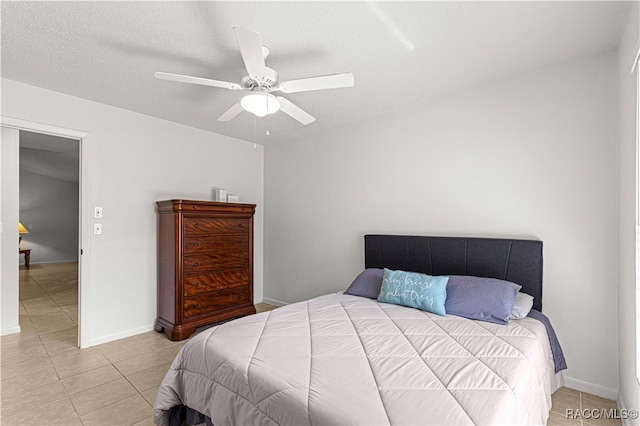 bedroom with light tile patterned floors, a textured ceiling, and ceiling fan