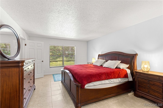 bedroom featuring light tile patterned floors and a textured ceiling