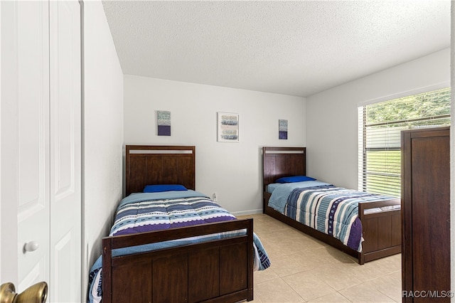 tiled bedroom with a textured ceiling