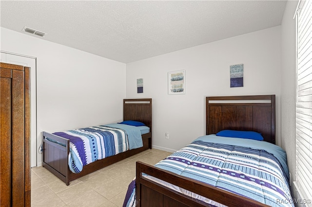 tiled bedroom featuring a textured ceiling