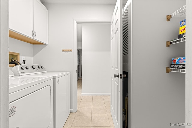 laundry area featuring independent washer and dryer, cabinets, and light tile patterned floors