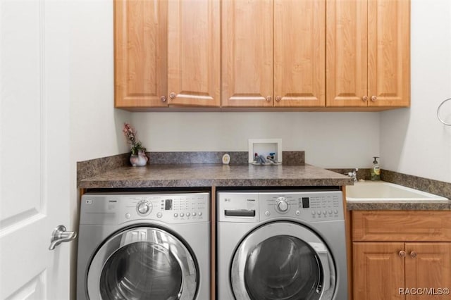 washroom featuring cabinets, washer and clothes dryer, and sink