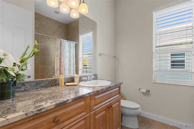 bathroom with toilet, vanity, tile patterned floors, and walk in shower