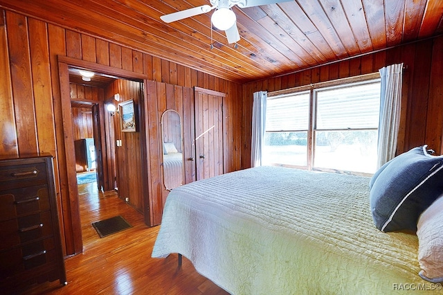 bedroom featuring hardwood / wood-style floors, ceiling fan, wood walls, and wood ceiling