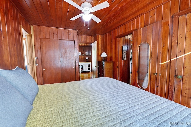 bedroom with wood ceiling, ceiling fan, and wood walls