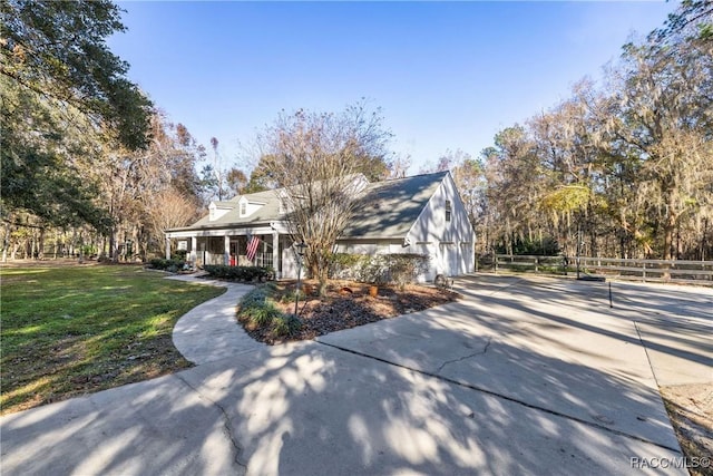 view of front of home with a garage, a front lawn, covered porch, and fence