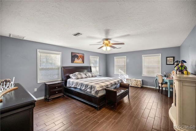 bedroom with dark wood-style floors, visible vents, and baseboards