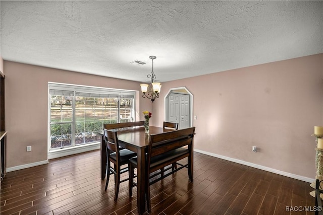 dining space featuring baseboards, visible vents, arched walkways, dark wood-style floors, and a notable chandelier