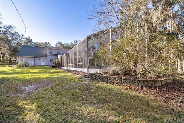 view of yard with a lanai and fence