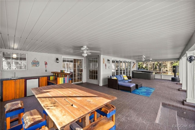 view of patio with exterior kitchen, outdoor dining space, and ceiling fan