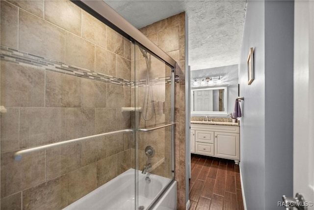 full bath featuring wood finish floors, shower / bath combination with glass door, and vanity