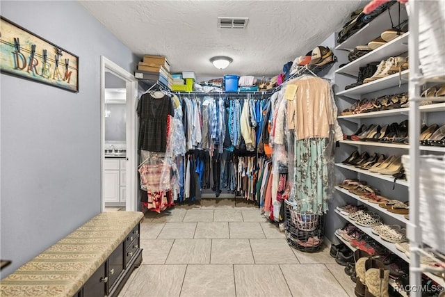 walk in closet with a sink and visible vents