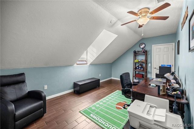 home office featuring baseboards, a ceiling fan, lofted ceiling with skylight, wood finished floors, and a textured ceiling