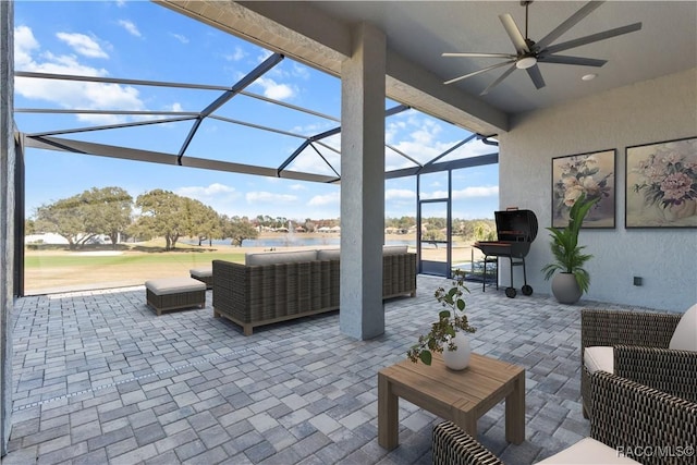 view of patio featuring glass enclosure, ceiling fan, and an outdoor living space