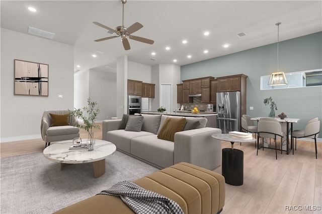 living room with light wood finished floors, ceiling fan, visible vents, and recessed lighting