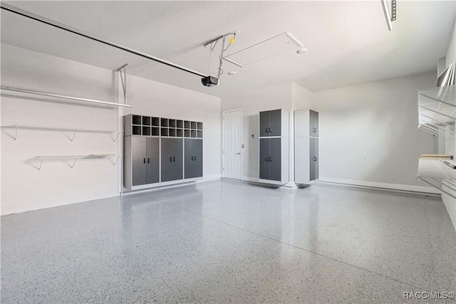 garage with baseboards and a garage door opener