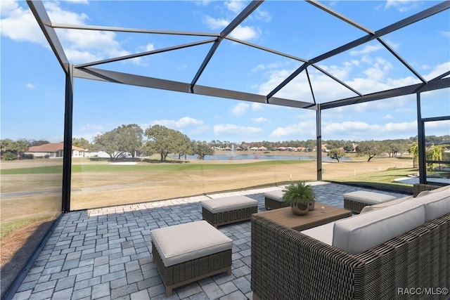 view of patio / terrace with glass enclosure, a water view, and an outdoor living space