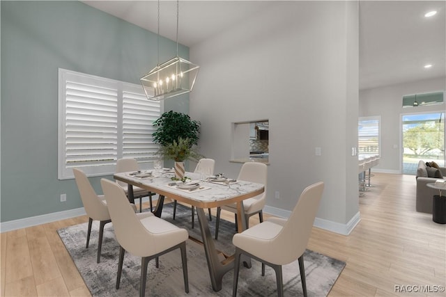 dining room with light hardwood / wood-style flooring and a notable chandelier