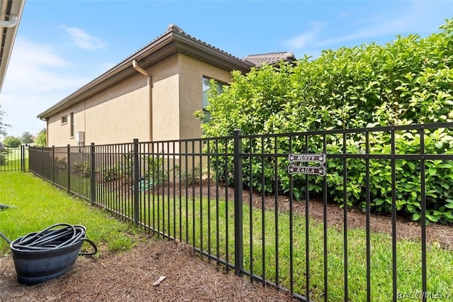 view of side of home featuring a yard, fence, and stucco siding