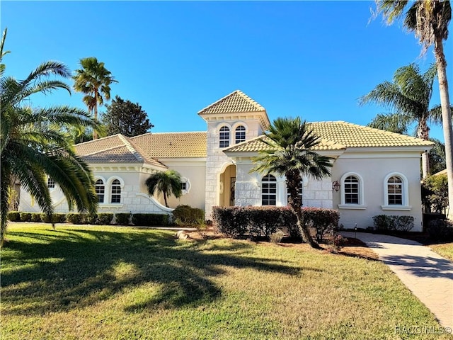 mediterranean / spanish-style house featuring a front lawn