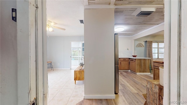 corridor with light tile patterned floors and crown molding