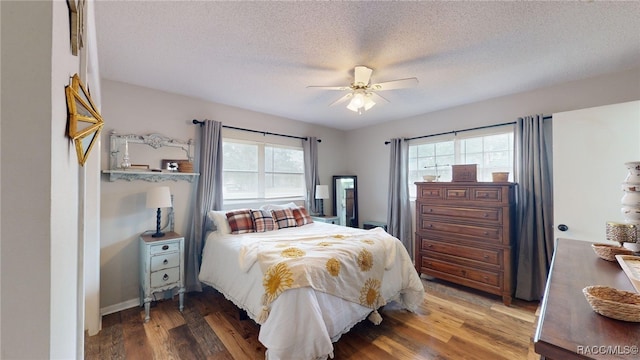 bedroom featuring hardwood / wood-style flooring, ceiling fan, and a textured ceiling