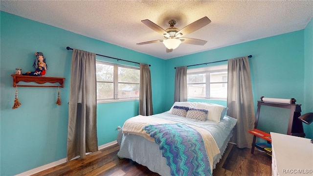 bedroom featuring ceiling fan, dark hardwood / wood-style floors, and a textured ceiling