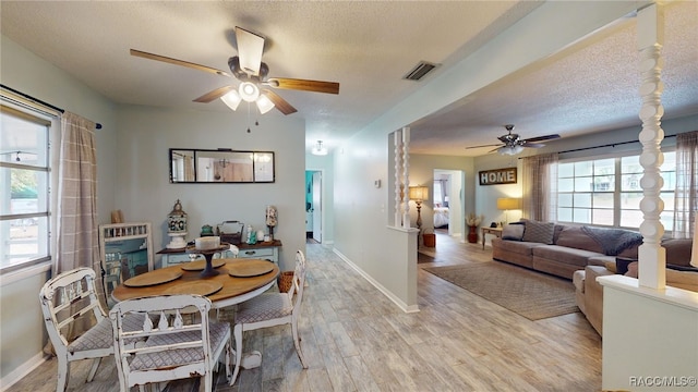 dining room featuring a textured ceiling, light hardwood / wood-style floors, and ceiling fan