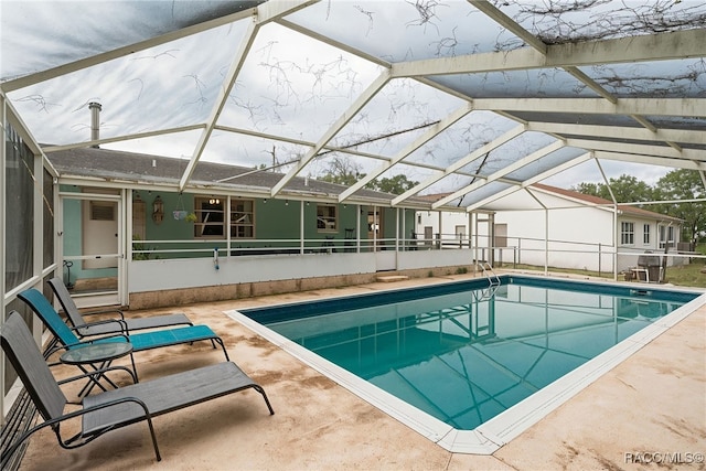 view of swimming pool featuring glass enclosure and a patio