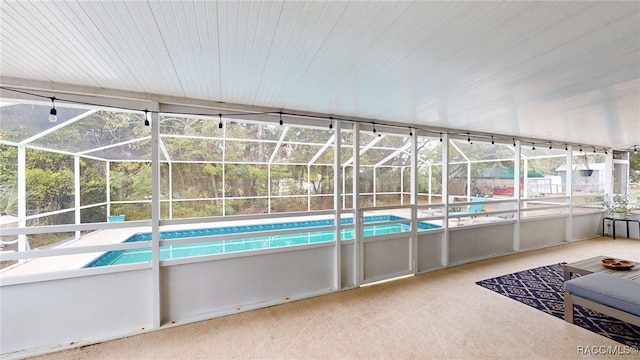 view of swimming pool with glass enclosure and a patio