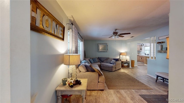 living room with ceiling fan and light wood-type flooring